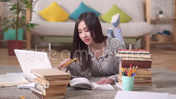 一位美丽的亚洲女孩带着书看镜头的肖像视频的预览图