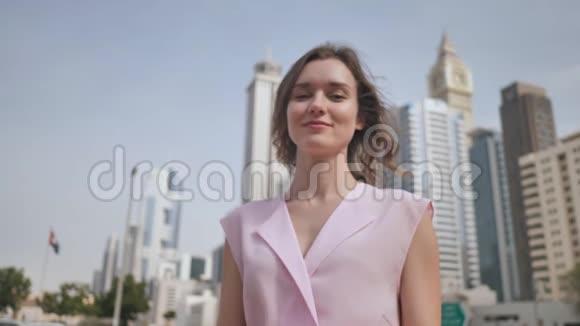 女孩手里拿着迪拜市中心背景下阿拉伯联合酋长国的钱视频的预览图