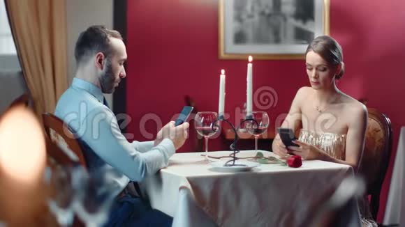 情侣聊天在无聊的浪漫约会中使用智能手机中型摄影机视频的预览图