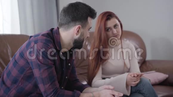 侧面看绝望的白人男子从模糊的红发女人的背景收回结婚戒指青年视频的预览图
