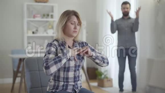 压力重重的白人妇女摘下结婚戒指向丈夫伸出手的肖像视频的预览图