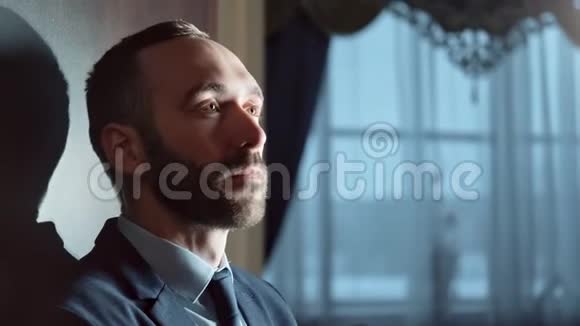 穿西装的男人穿着漂亮的长胡子在豪华酒店内部思考近距离拍摄4k红色相机视频的预览图