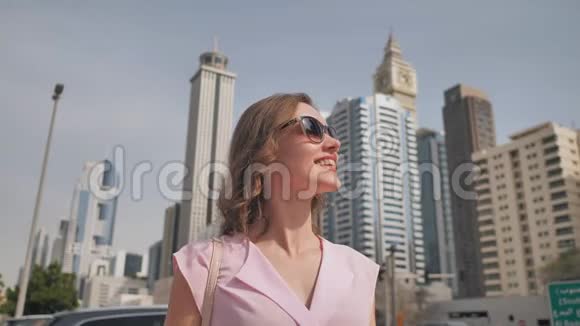 快乐的女孩在摩天大楼的背景下走在迪拜的中心视频的预览图