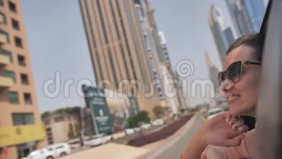 快乐女孩从车窗欣赏迪拜的景色并向城市发送一个吻视频的预览图