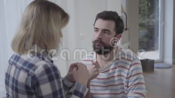 悲伤的白人年轻人带着爱看妻子给他结婚戒指的肖像女性回归婚姻象征视频的预览图