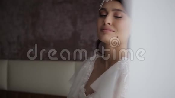 美丽的千禧新娘头上戴着花环穿着白色婚纱手里拿着一束鲜花视频的预览图