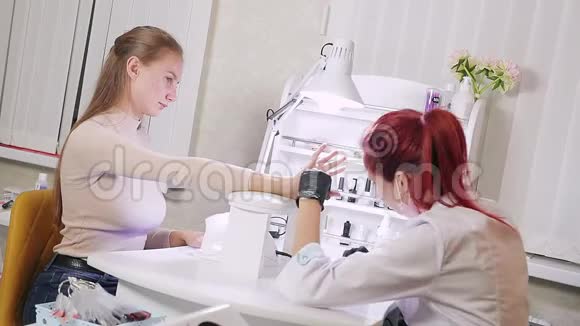 美容浴中的美甲医生正在客户指甲上涂胶女孩用紫外线灯晒指甲视频的预览图