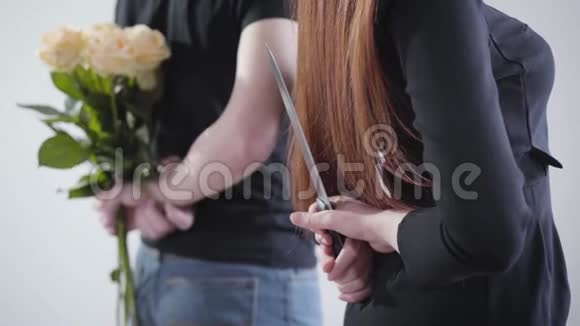 一个面目全非的年轻红发女人背后拿着一把大刀头发模糊的男人拿着一束黄色玫瑰视频的预览图