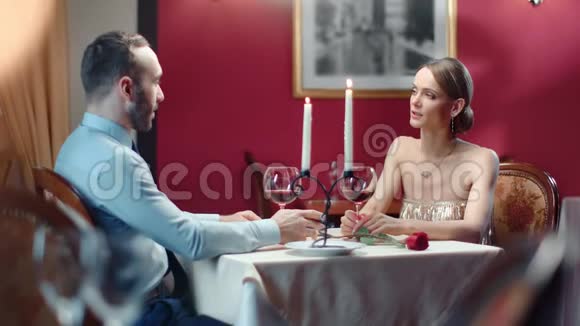 时尚情侣在优雅餐厅的晚餐约会时微笑着交谈中型摄影机视频的预览图