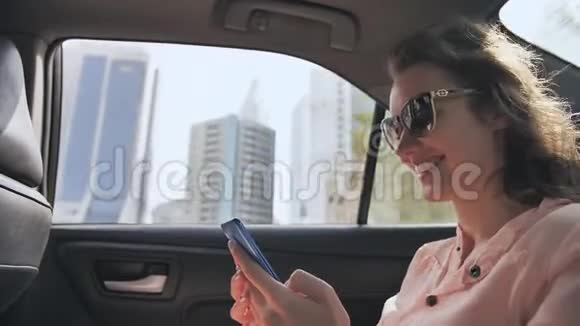 一个坐在移动车里的女孩正在手机上输入一条信息迪拜城视频的预览图