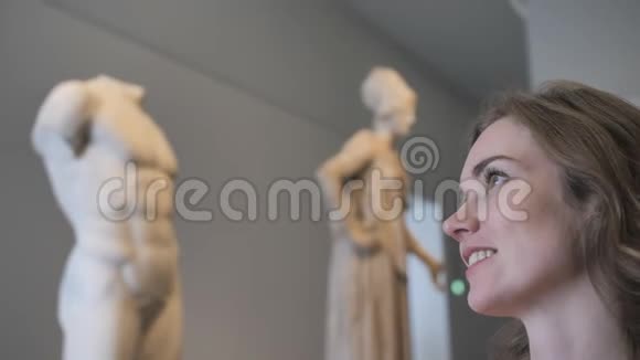 一个年轻女孩在博物馆里看展品视频的预览图