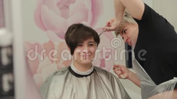 专业的理发师女性给一个带理发师的女孩理发视频的预览图