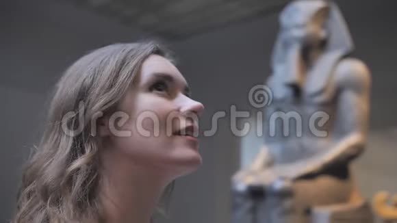 一个年轻女孩在博物馆里看展品视频的预览图