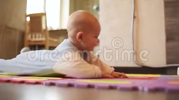 妈妈教宝宝在房子里的地毯上爬行妈妈宝宝视频的预览图