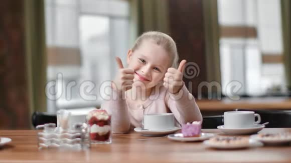 肖像女孩笑着在咖啡馆摆姿势露出冷静的大拇指中型近距离拍摄4k红色相机视频的预览图
