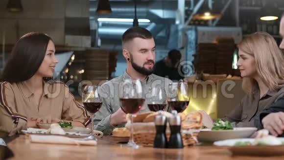 两对幸福的夫妇在餐厅享受友好的交谈一起玩得很开心4k龙红相机视频的预览图