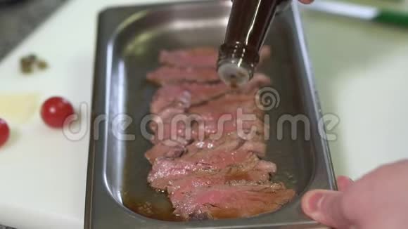 厨师用手浇一片生肉与酱汁腌制它在厨房做饭模糊的视频的预览图