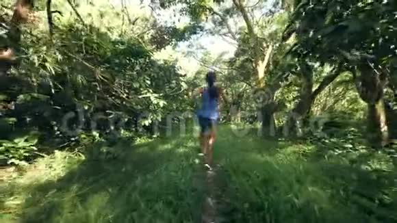 欢快的女孩在森林里绿色的草地小径上散步跳舞视频的预览图