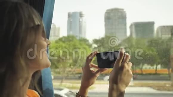 一个女孩乘公共汽车穿过阿布扎比市并在电话上制作视频阿联酋视频的预览图