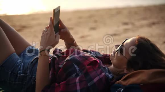 日落时分一位年轻女子在海滩上放松视频的预览图