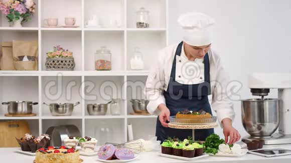 女性糖果师在厨房完成装饰的新鲜蛋糕中型摄影机拍摄视频的预览图