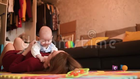 妈妈和她躺在公寓地板上的孩子玩妈妈和儿子在一起视频的预览图