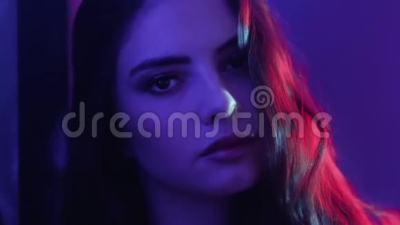 五颜六色的光脸温柔的女孩紫色的霓虹灯视频的预览图