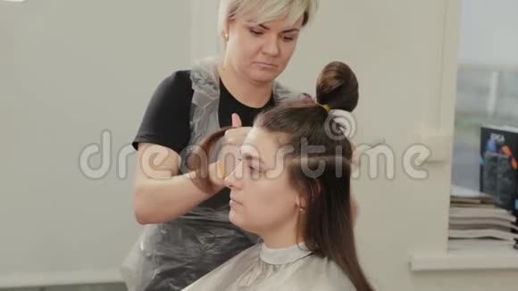 专业的理发师女士为客户理发准备头发视频的预览图