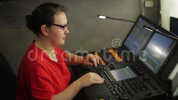 遥控器上的一个女照明器为节目制作舞台灯光视频的预览图