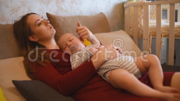 小孩睡在妈妈身上妈妈抚摸宝宝视频的预览图