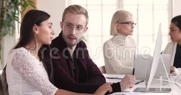 年轻的女商人和男同事一起工作用电脑办公视频的预览图