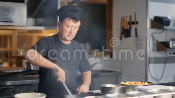 自信的韩国男厨师在炉子上准备美味的热食4Kk用红色摄像机拍摄视频的预览图
