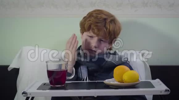 悲伤的白种人红头发的孩子流感拿起杯子喝茶就像坐在床上一样可爱的不安不健康的孩子视频的预览图