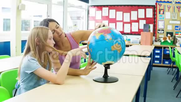 白人小学女孩和她的老师看着一个地球视频的预览图