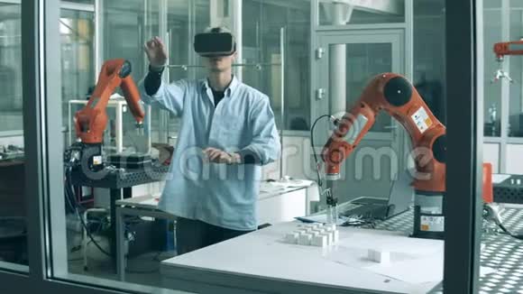 男性研究员戴着VR眼镜在实验室里戴着机器人视频的预览图
