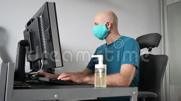 在家工作的人戴着防护面罩用消毒凝胶清洁他的手冠状病毒检疫工作视频的预览图