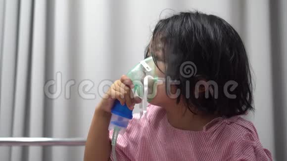 一个戴着氧气罩的亚洲小女孩在医院里用喷雾器呼吸支气管炎呼吸系统和视频的预览图