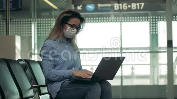离开休息室和一位戴着医疗面罩的女士用笔记本电脑视频的预览图