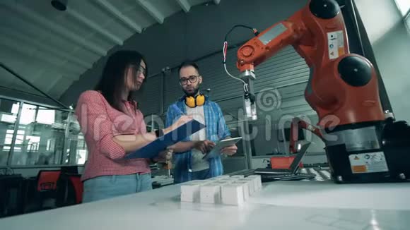 两位工程师正在记录一个机器人的实验视频的预览图
