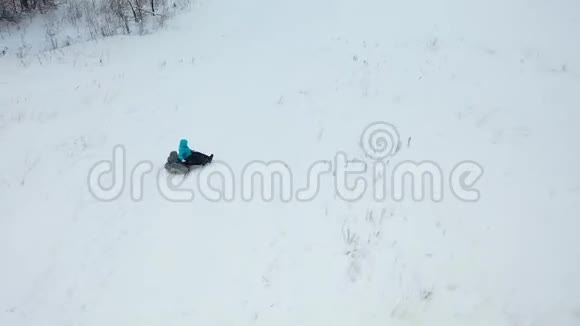 幸福的家庭乘坐和微笑的雪管在雪道上慢动作冬天的雪景户外运动视频的预览图