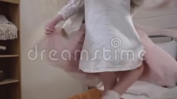 一幅年轻的白种人女孩穿着新衣服躺在床上的肖像快乐的孩子准备好视频的预览图