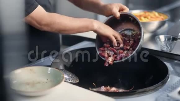 男厨师在餐厅的煎锅中加入生肉近距离拍摄4k红色相机视频的预览图