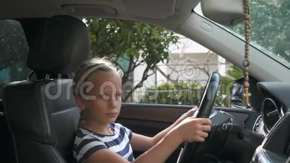坐在汽车轮子旁的八岁女孩视频的预览图