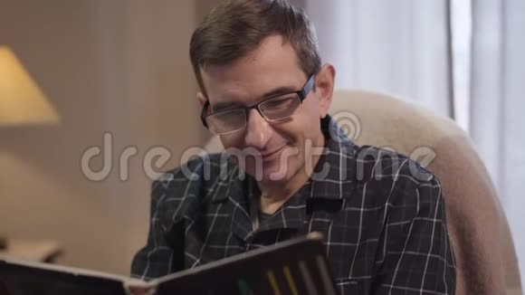 特写肖像积极的中年白种人男子看相册和微笑戴眼镜的成年男子视频的预览图