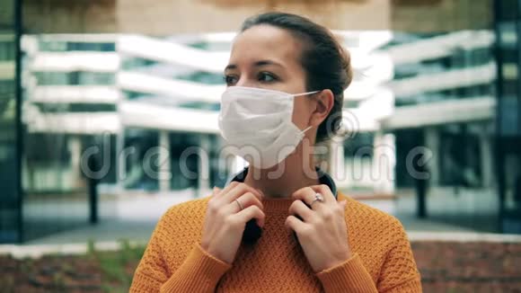 一个戴着医用面具的女人在四处张望冠状病毒流行大流行的概念视频的预览图