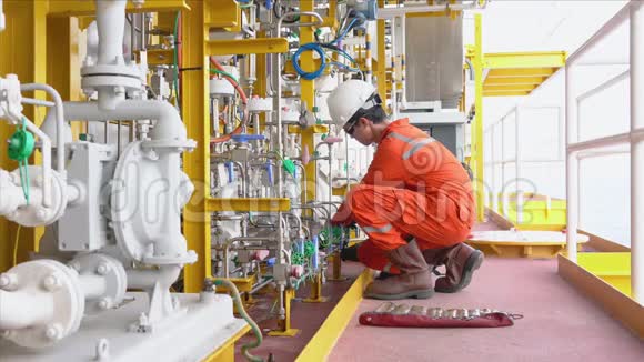 机械技术人员在海上油气井口远程平台上拧紧化工泵系统的油管配件视频的预览图