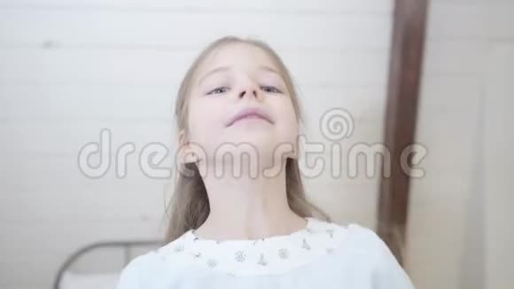 镜头跟随小白种人女孩倒在柔软的床上活泼开朗的孩子在室内享受自由视频的预览图