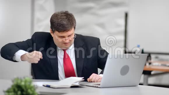 紧张的商务人员在电脑突然故障时坐在桌子前的坏电脑视频的预览图