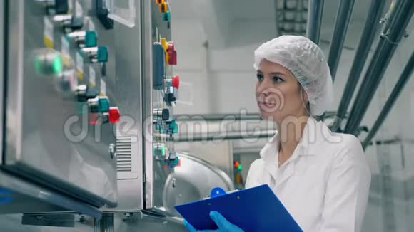 女士专家正微笑着观察工厂的机器视频的预览图