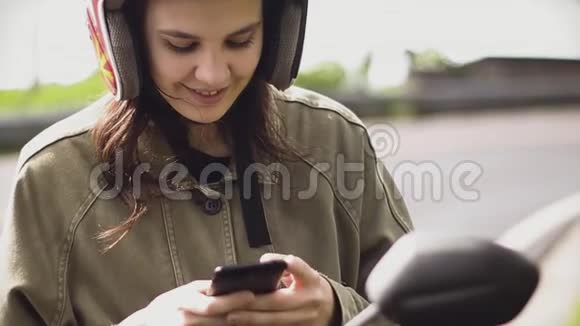 女孩旅行者在电话里发短信在日出时停在路边的自行车上视频的预览图